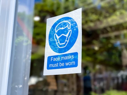 covid-19 mask required sign posted on retail store door