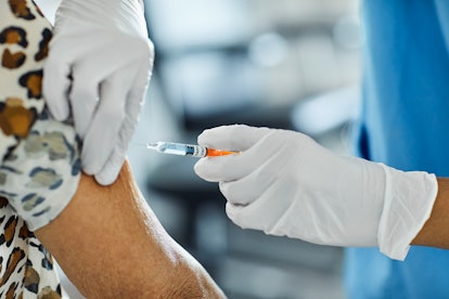 Cropped image of nurse injecting Covid-19 Vaccine to a patient. Female healthcare worker is working ...