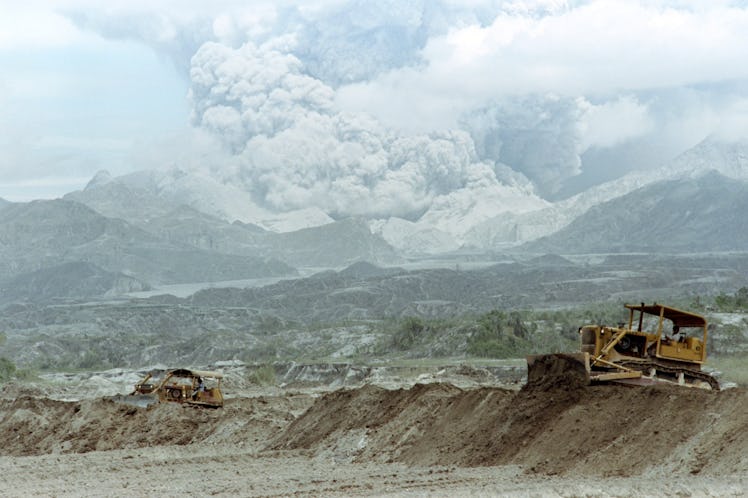 Bulldozers rush to repair collapsed Taug Dike, on June 29, 1991 as lake of trapped volcanic mudflow ...