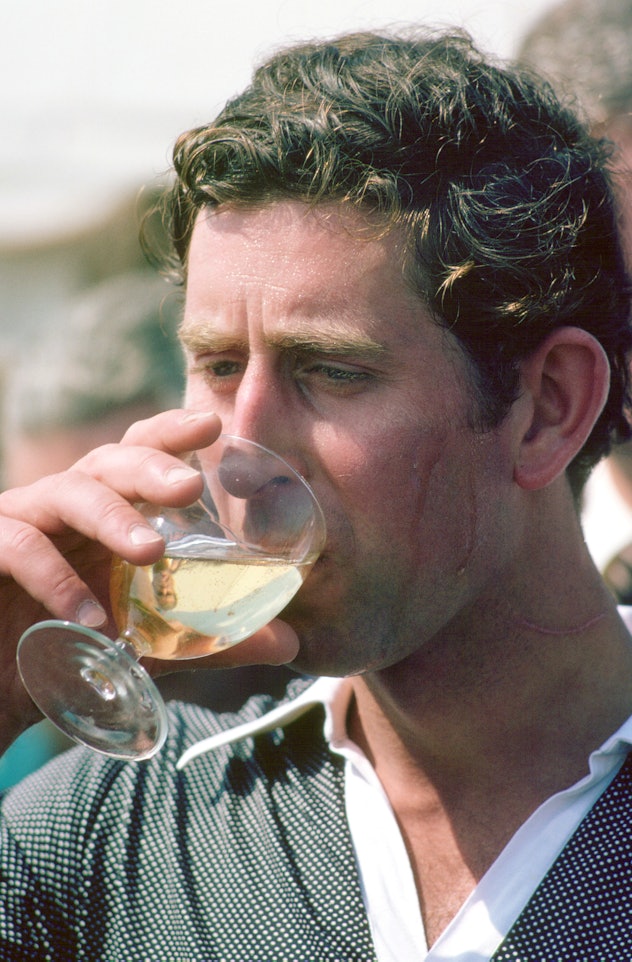 Prince Charles drinks after a polo match.