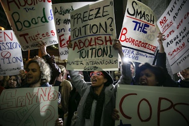 Students hold signs as they stage a demonstration against student debt at Hunter College in New York...