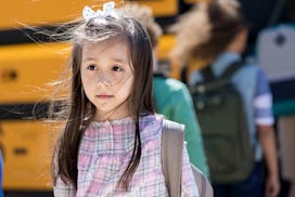 Hispanic elementary schoolgirl dreads the first day of school. She has a sad facial expression.