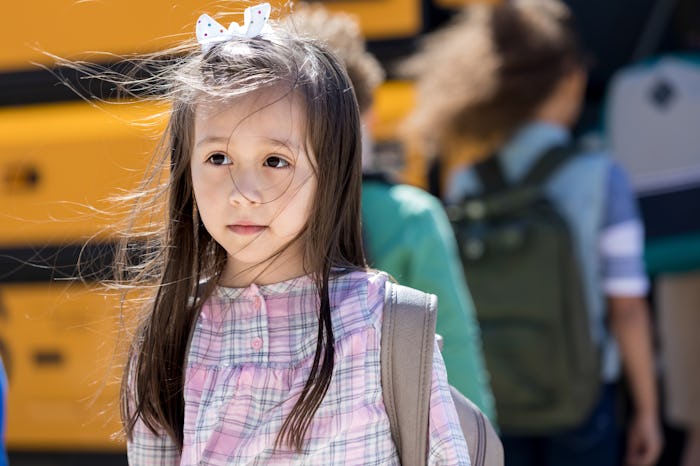 Hispanic elementary schoolgirl dreads the first day of school. She has a sad facial expression.