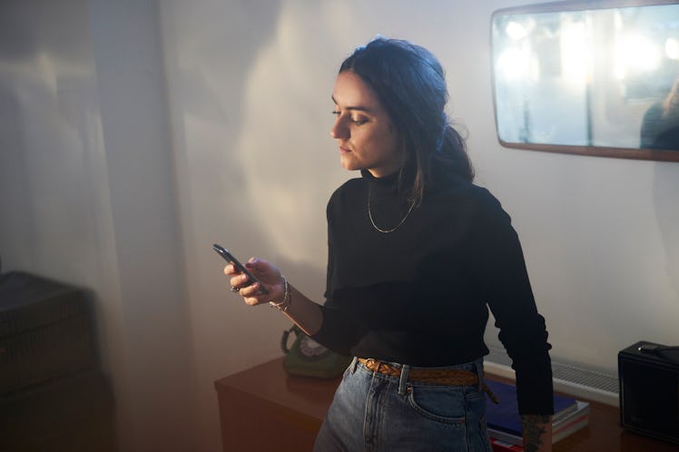 Young woman using her smart phone at trendy home in Shoreditch