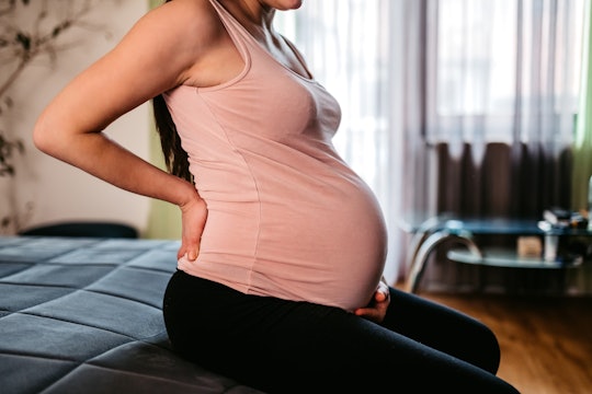 Young pregnant woman having backaches in the last trimester of pregnancy.