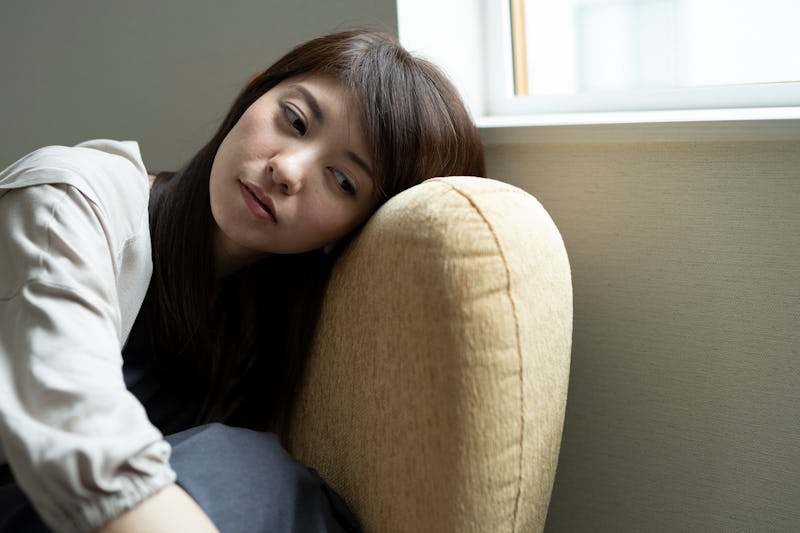 woman feeling down sitting on the couch