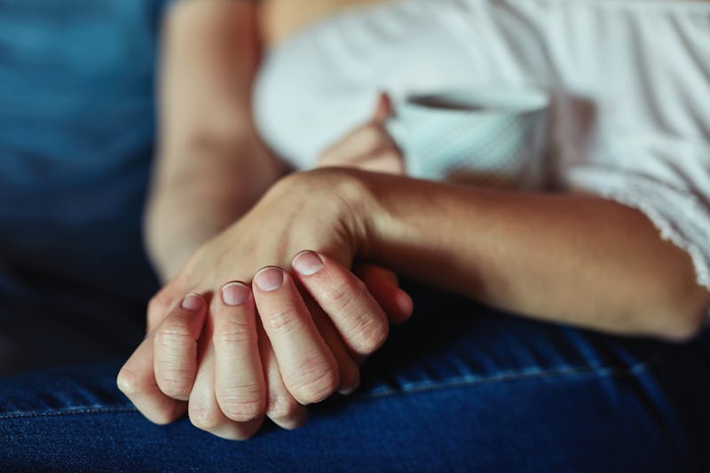 Friends hold hands, comforting a mom who's lost a child on mother's day.