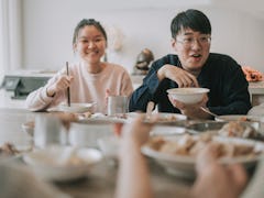 Asian chinese siblings enjoying family chinese new year reunion dinner having traditional dishes at ...