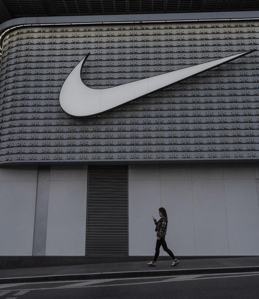 BEIJING, CHINA - APRIL 08: A woman walks outside a Nike store at a shopping area on April 8, 2021 in...
