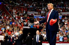 US President Donald Trump throughs MAGA caps to supporters as he arrives for a "Keep America Great" ...