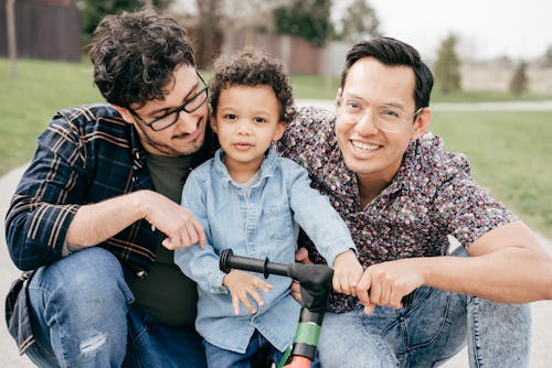 Two dads with toddler son having fun outdoor