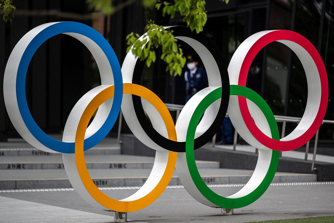 Security guards are seen through the Olympic Rings near the National Stadium for the Tokyo 2020 Olym...