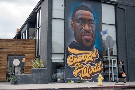 LOS ANGELES, CALIFORNIA - APRIL 21: A woman without a mask walks past a mural of George Floyd that r...