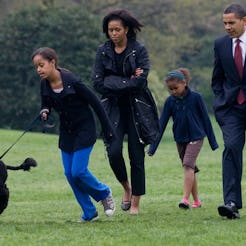 Malia Obama walks her new six-month old Portuguese water dog Bo alongside US President Barack Obama,...