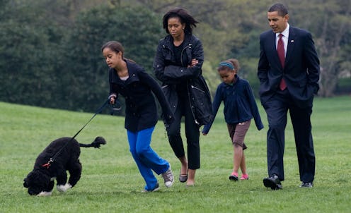 Malia Obama walks her new six-month old Portuguese water dog Bo alongside US President Barack Obama,...