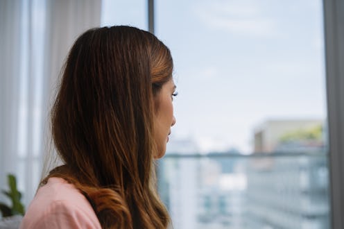 woman looking out her window