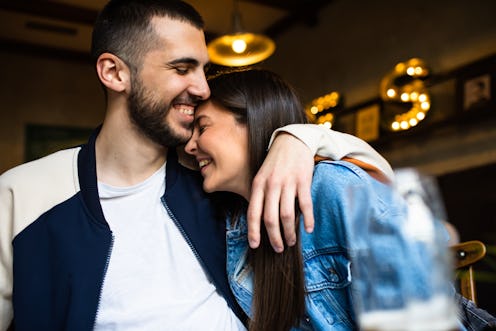 A cute young couple is sharing a loving moment while out for drinks at a bar