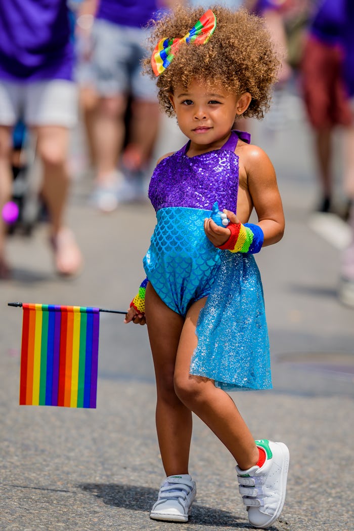 A girl holding a rainbow flag at the Pride March NYC.