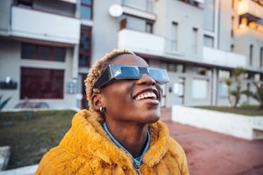 Teenage girl looking at solar eclipse wearing the proper protective eyeglasses