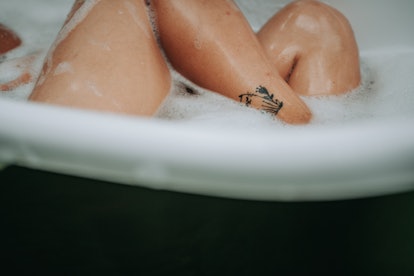 A woman's legs in a bath. Not having enough lubrication can be a reason for bleeding after sex. 