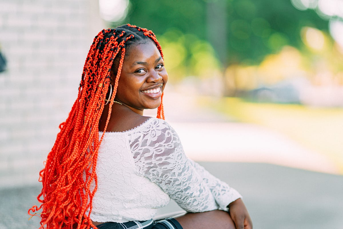 Young woman with red hair, smiling and having the best week of June 21, 2021, per her zodiac sign.