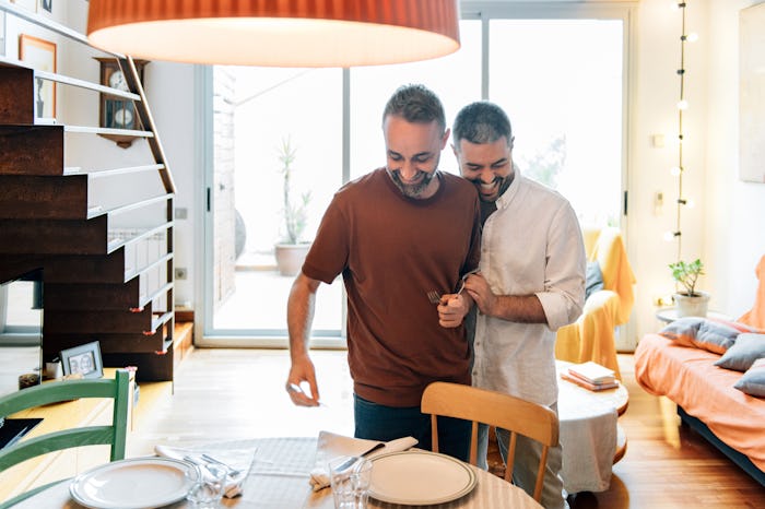 Gay Couple flirting while setting the table for guests