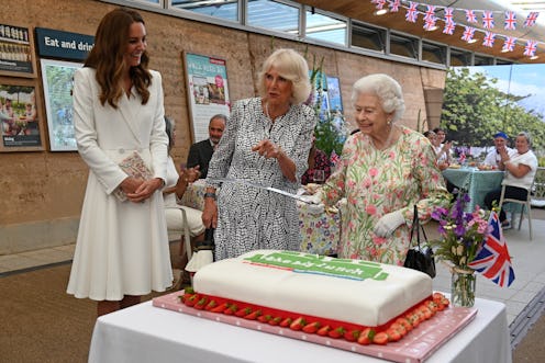 ST AUSTELL, ENGLAND - JUNE 11: Queen Elizabeth II (C) considers cutting a cake with a sword, lent to...