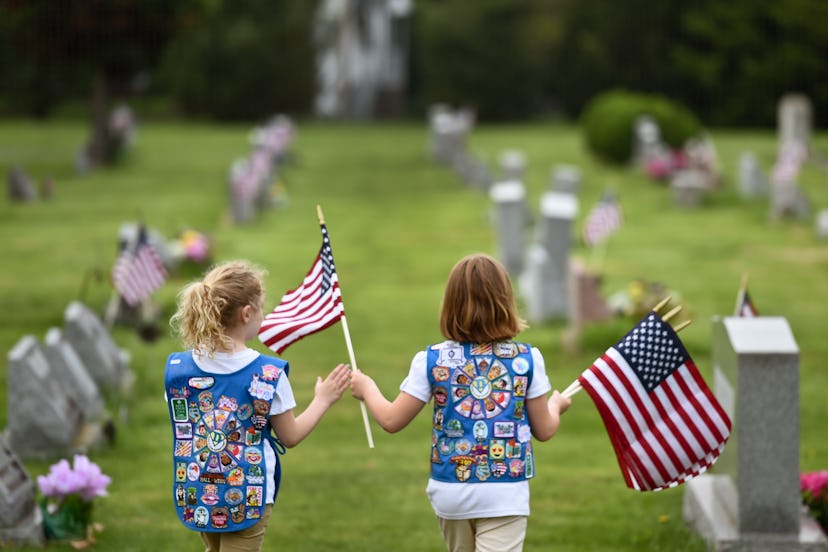 Girl Scout Daisy Troop 1080 place flags on the graves 