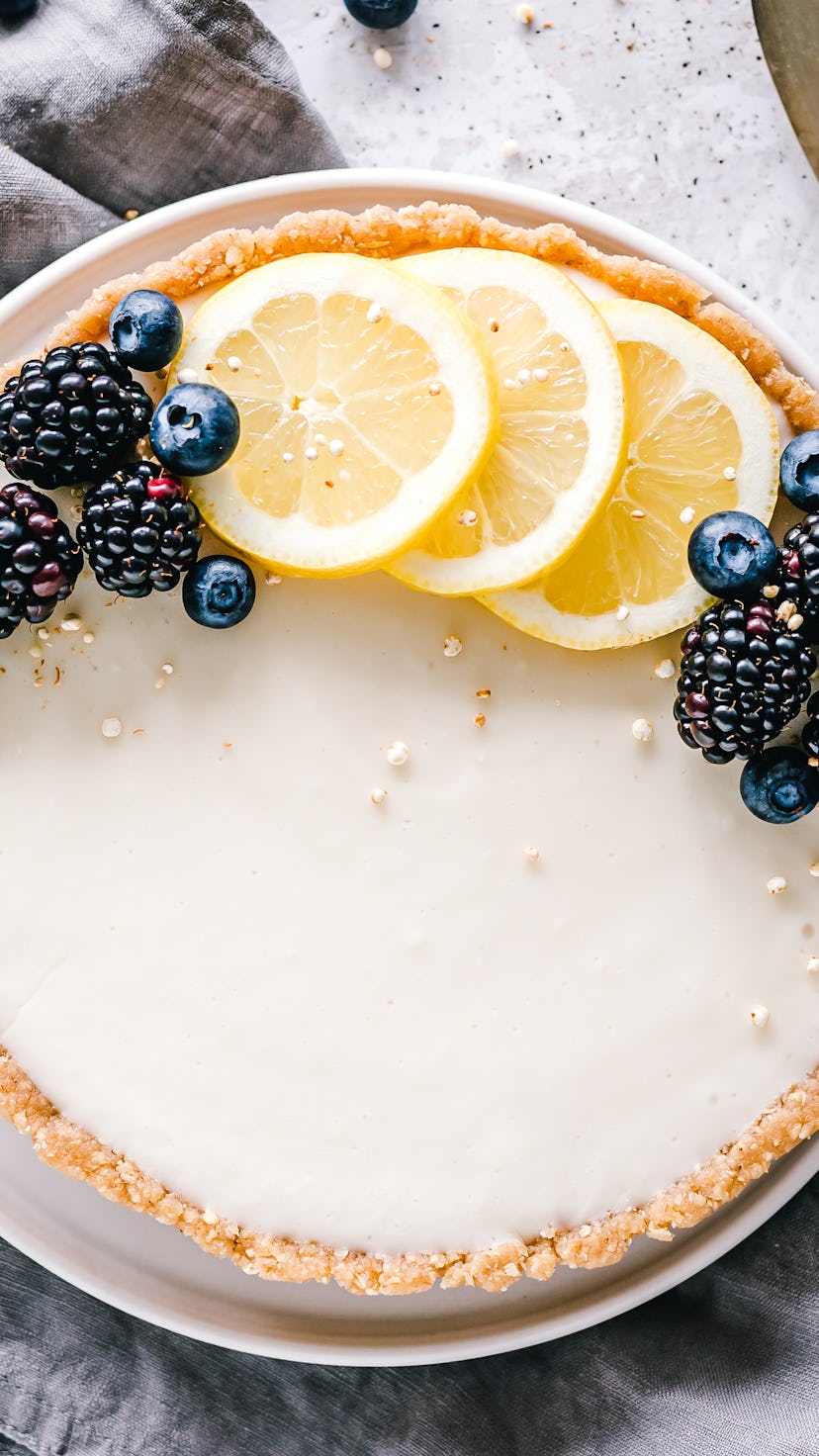 lemon tart with blueberries and fresh lemon garnish, shot from above
