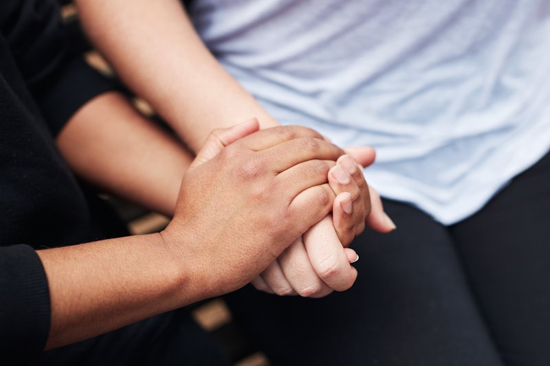 Two women hold hands, comforting each other. Here are 5 things not to say to people who've lost thei...