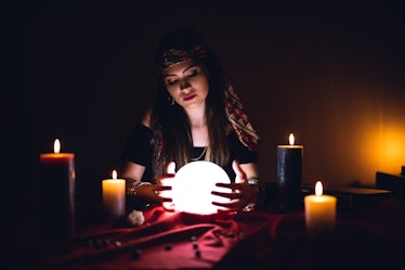 Young caucasian woman fortune teller and crystal sphere.