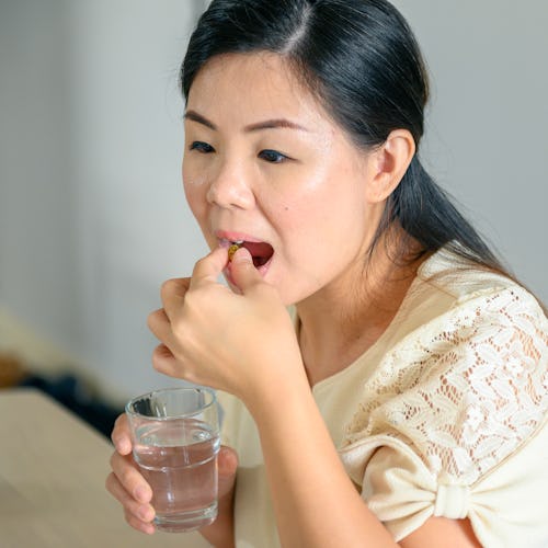 Asian woman consuming medicines in the morning