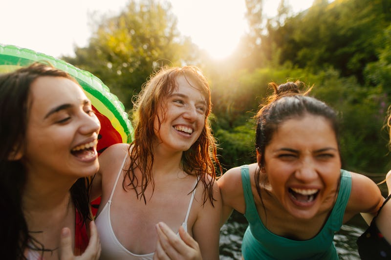 Portrait of smiling girlfriends enjoying a summer day on the river. The most common personality type...