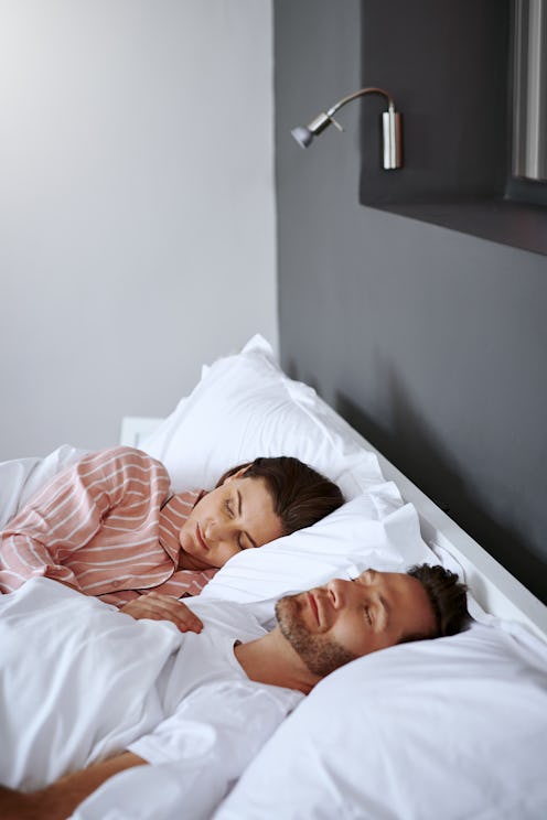 A couple sleeps together, looking unhappy. Wondering, "why can't i fall asleep with my boyfriend?" ...