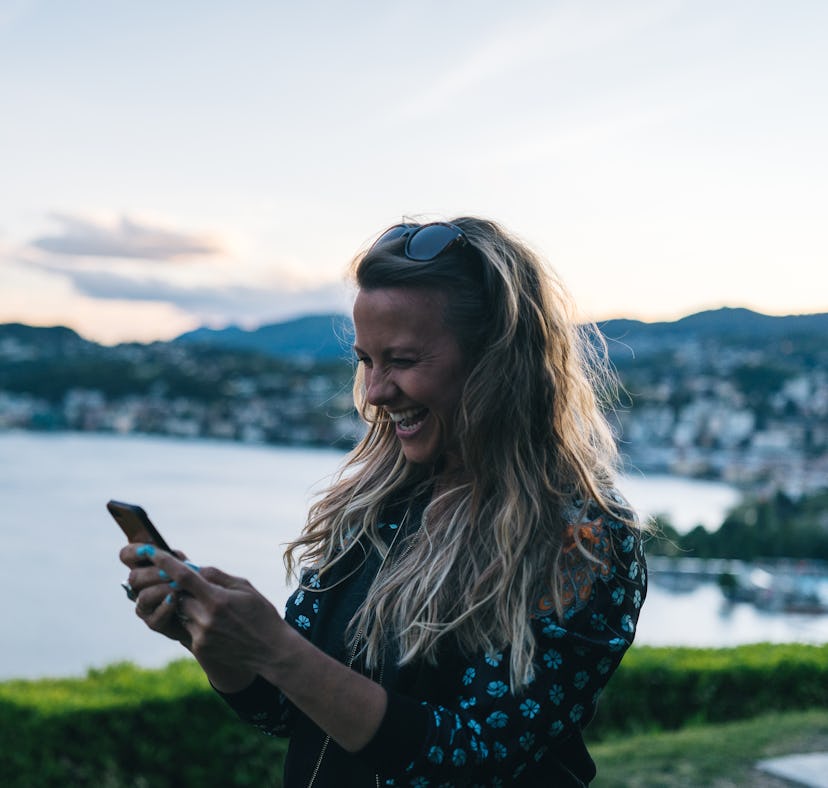 She laughs with excitement, coastline of Lake Lugano behind