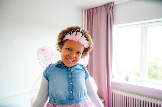 Shot of a little girl wearing fairy wings and a crown while playing in her bedroom