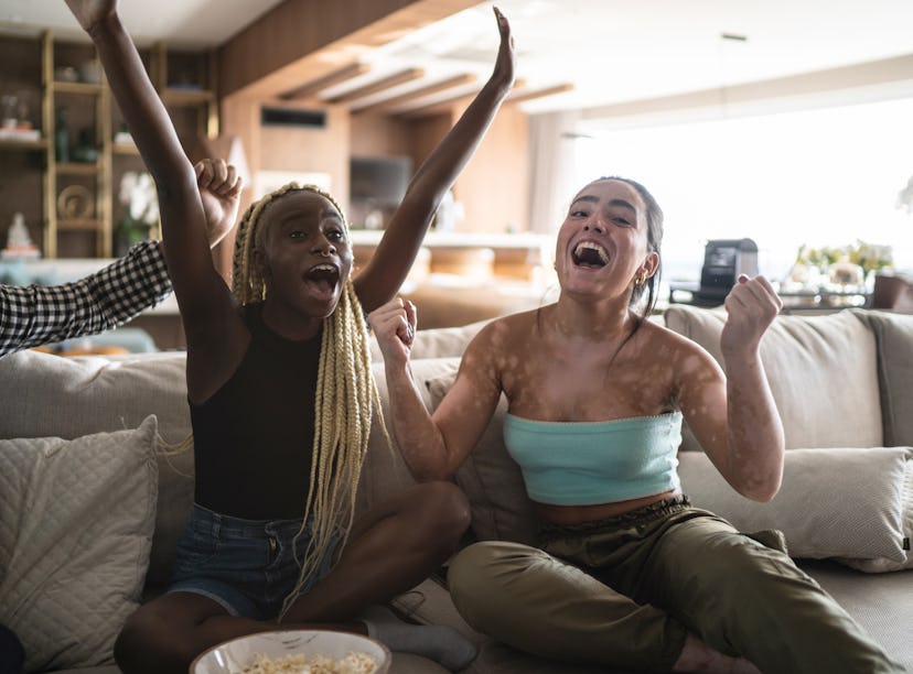 Friends together watching the 2021 Olympics on television at home together might need captions to ca...