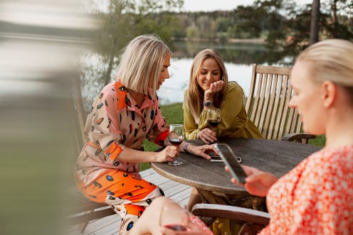 A group of women drink wine at a lake house. As the pandemic has ended, social drinking has resumed ...