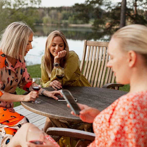 A group of women drink wine at a lake house. As the pandemic has ended, social drinking has resumed ...