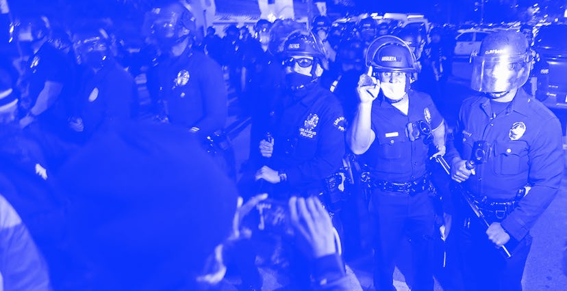 LOS ANGELES, CA - MARCH 24, 2021. Protesters and police exchange words near a homeless encampment in...