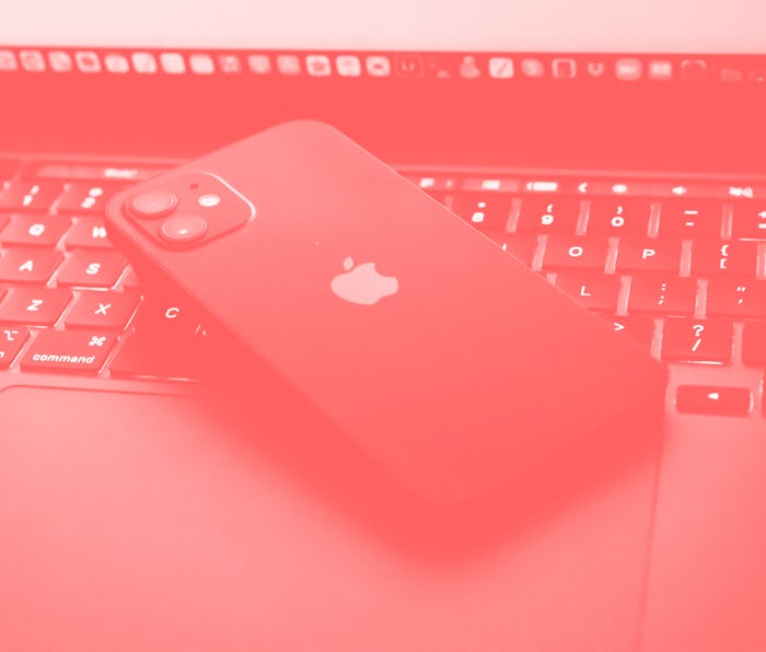 TOKYO, JAPAN - 2021/06/06: In this photo illustration, Apples iPhone 12 seen placed on a MacBook Pro...