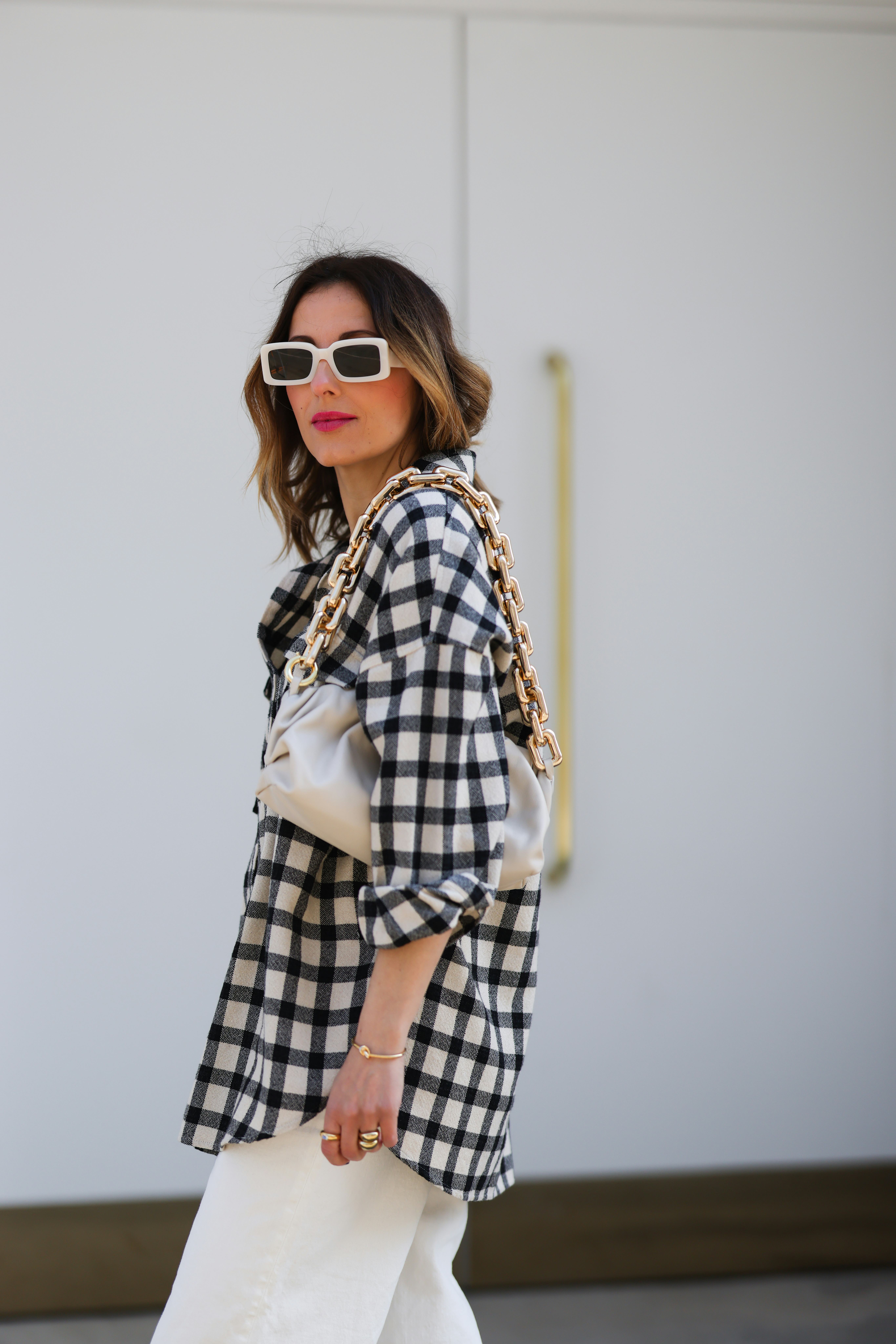 Elise Soho walking in the street and wearing a black and white Checkerboard Shirt