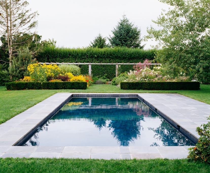 a beautifully landscaped pool with raised garden beds