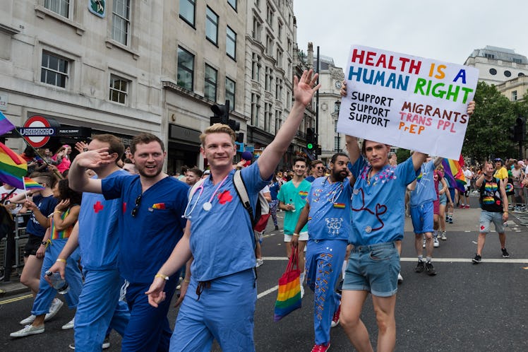 NHS doctors take part in the 2019 Pride parade in London parade, carrying rainbow flags and a sign r...
