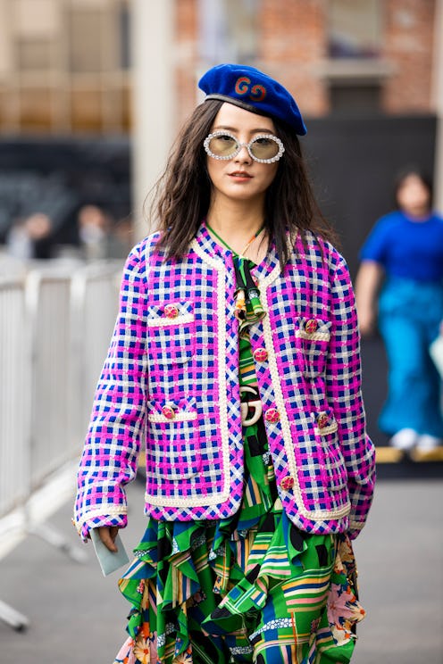 MILAN, ITALY - SEPTEMBER 22:  A guest, wearing a printed maxi dress, pink and blue decorated jacket,...