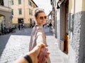 A woman holds hands with her partner while traveling through Italy in a photo that's as cute as a lo...