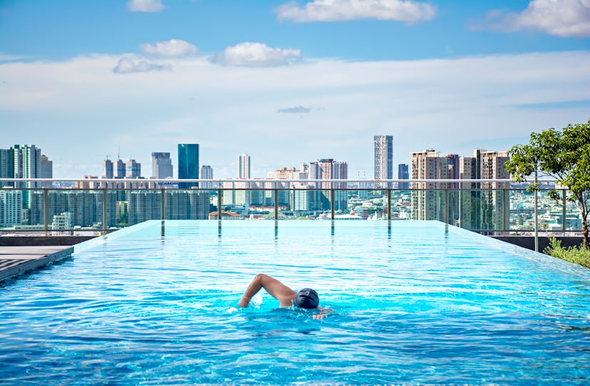 A person swims in a rooftop pool. Swimming requires a lot of mental focus.
