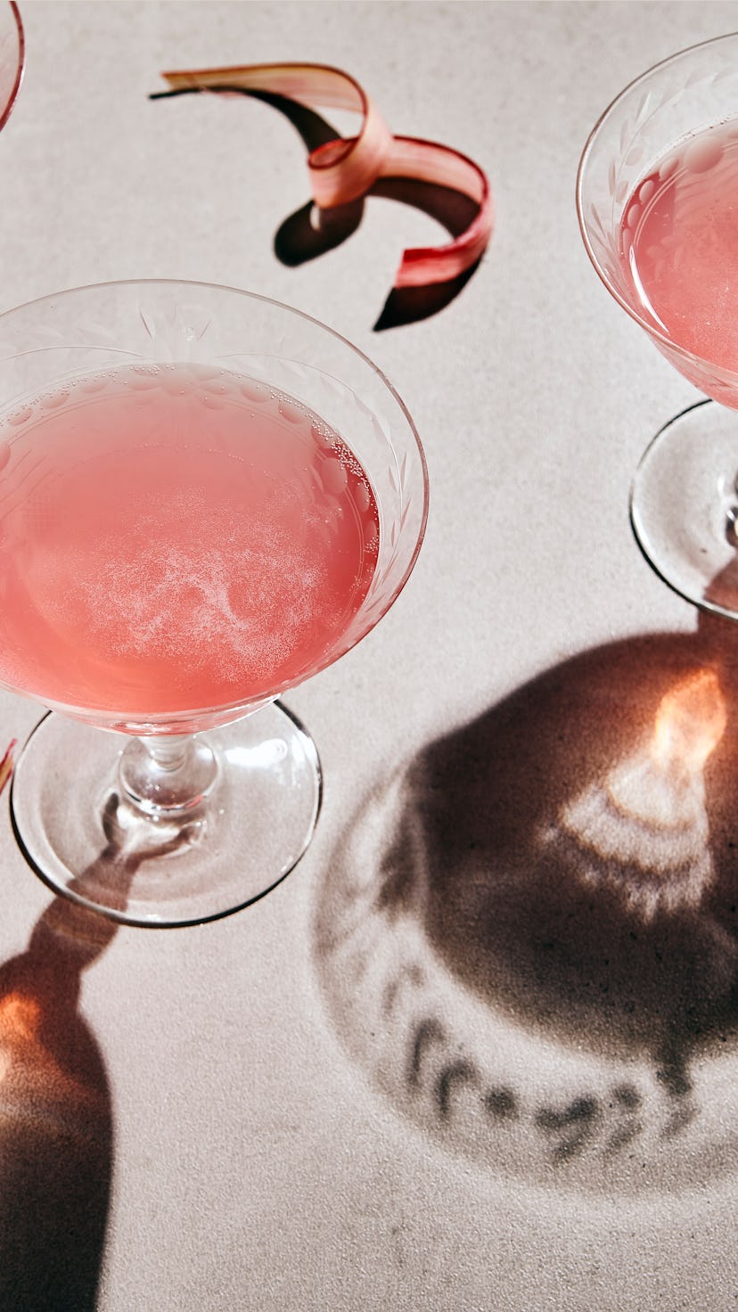 3 glasses of rhubarb sparkling mocktail or wine on grey table with dark shadows