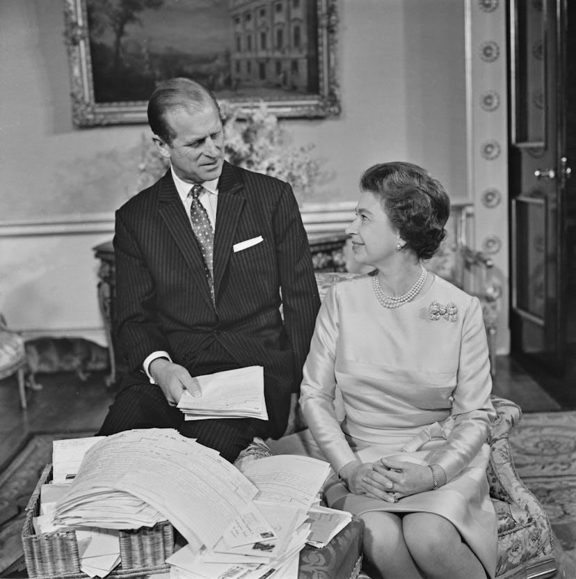 Queen Elizabeth II and Prince Philip, the Duke of Edinburgh (1921 - 2021) sort through their mail on...