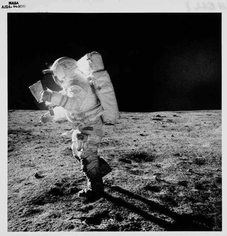 American NASA astronaut Edgar Mitchell (1930-2016) studies a map as he walks across the lunar surfac...